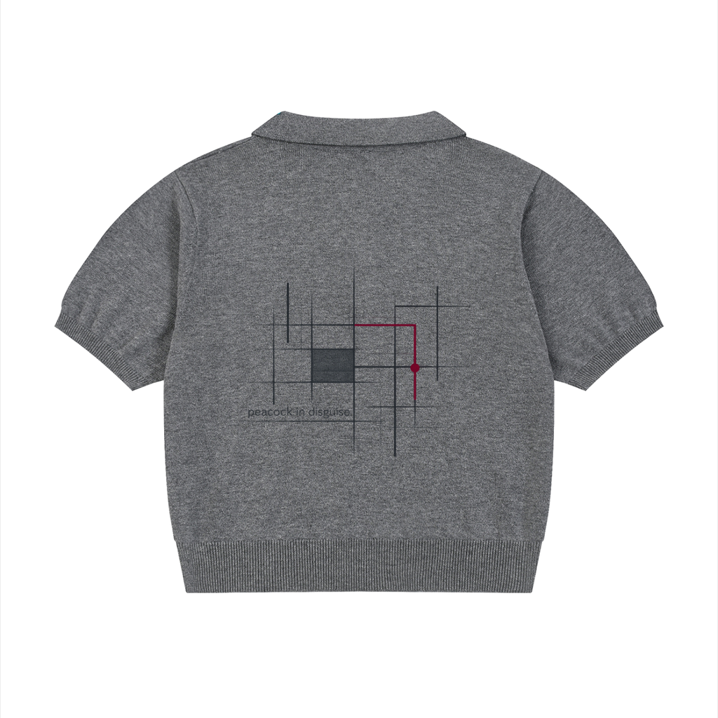 Back of the heather grey knit polo with a charcoal line-grid artwork, one burgundy accent and small “peacock in disguise.” lettering