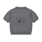 Back of the heather grey knit polo with a charcoal line-grid artwork, one burgundy accent and small “peacock in disguise.” lettering