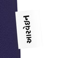 Close-up of the આરવેઇન wordmark tag on the navy Mor canvas tote