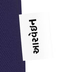 Close-up of the આરવેઇન wordmark tag on the navy Mor canvas tote
