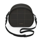 Peacock in Disguise grid round box bag in black nappa leather with a tonal grid pattern and crossbody strap, angled front