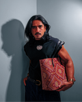 Model in a black tank holding the red Mor Bandhani tote