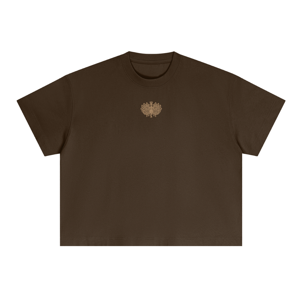 Embroidered Mor boxy tee in brown, front, with a small gold embroidered peacock emblem on the chest
