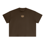 Embroidered Mor boxy tee in brown, front, with a small gold embroidered peacock emblem on the chest
